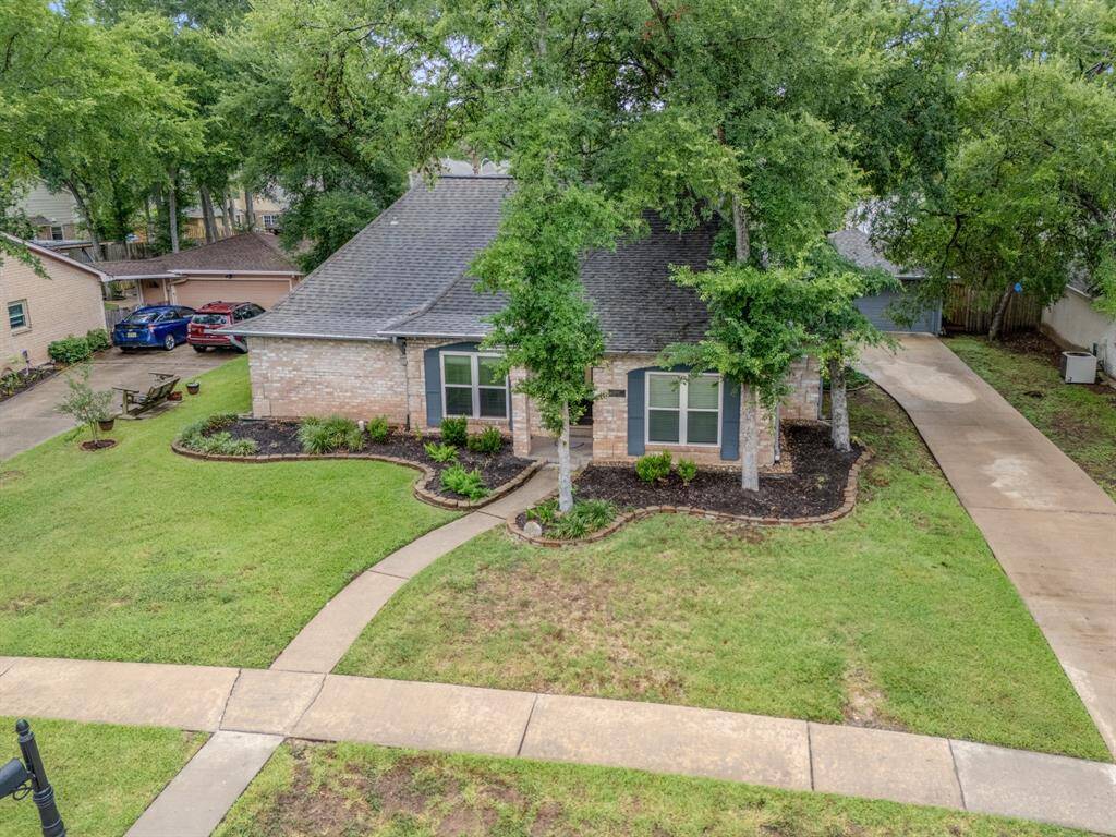 Well-maintained front yard and mature trees. Features a long driveway and tasteful landscaping, offering a welcoming curb appeal.