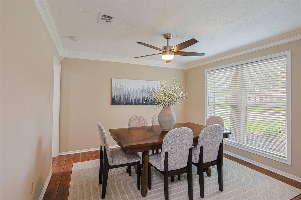 This dining room features a large window, allowing plenty of natural light creating  a cozy and inviting atmosphere.