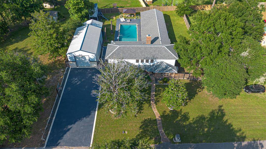 Charming two-story home, set on a spacious lot with mature trees. The walkway leads to the front entrance, offering great curb appeal and a welcoming atmosphere.