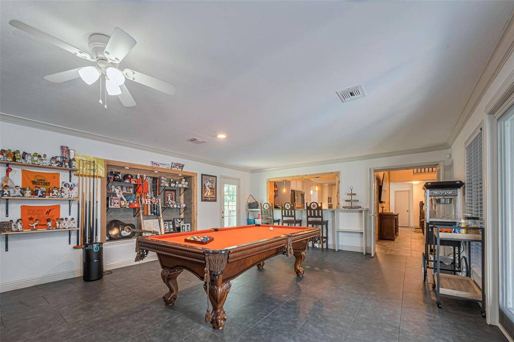 The gameroom is located off the kitchen and living room, and overlooks the backyard.