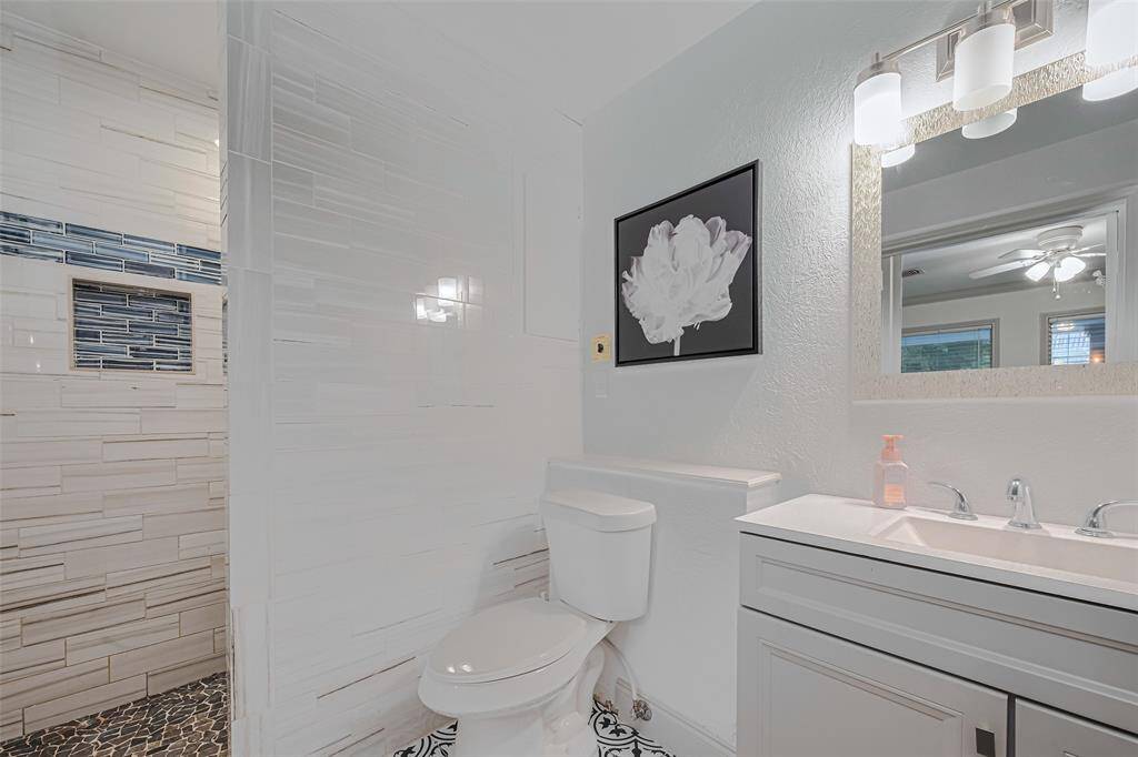 This bathroom features a modern subway tile walls, vanity with a large mirror, and stylish lighting.