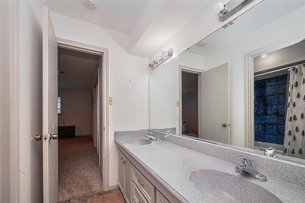 Second level bathroom with double sinks and large mirror.