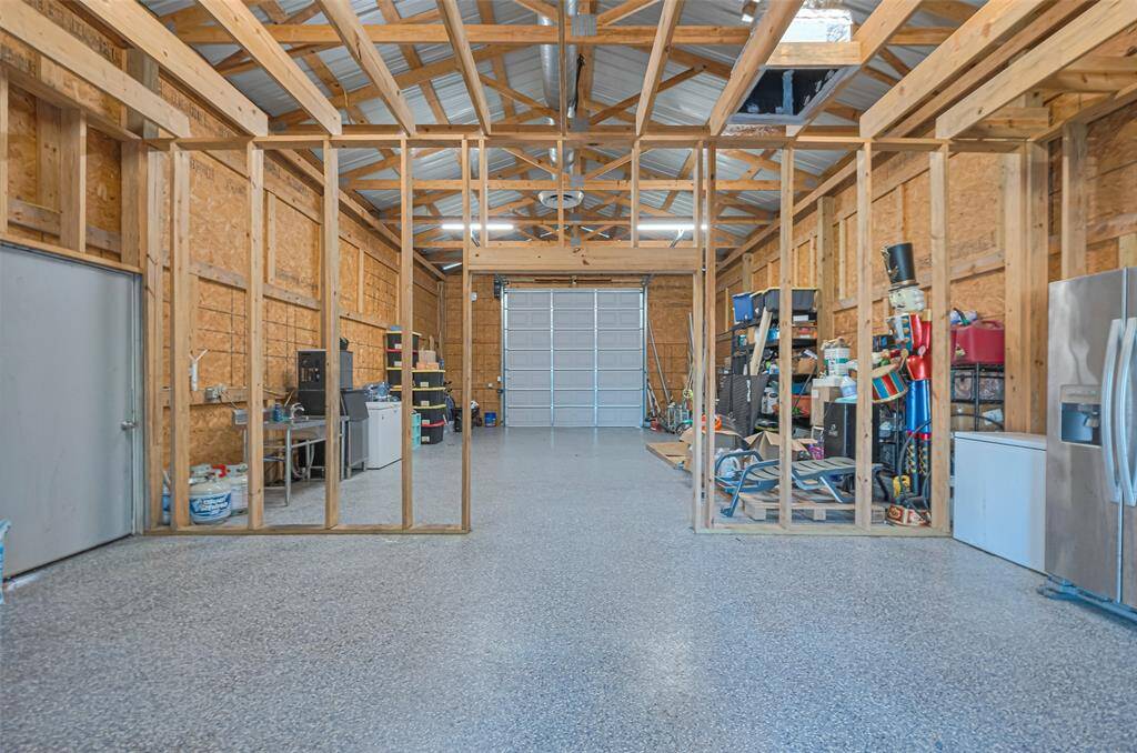 This is the inside of garage/workshop with a large roll-up door. Perfect for multiple uses!