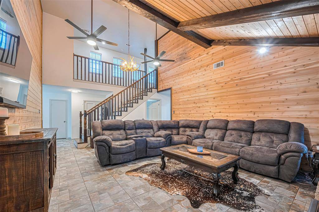 The staircase with a wooden railing leads to the upper level, enhancing the open, airy feel of the space.
