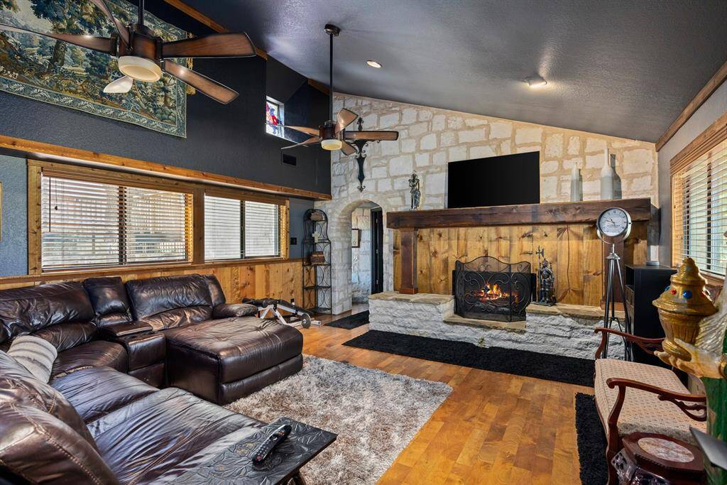 Great/family room features extra large custom-built stone gas log fireplace with a seated hearth & solid cedar mantle.