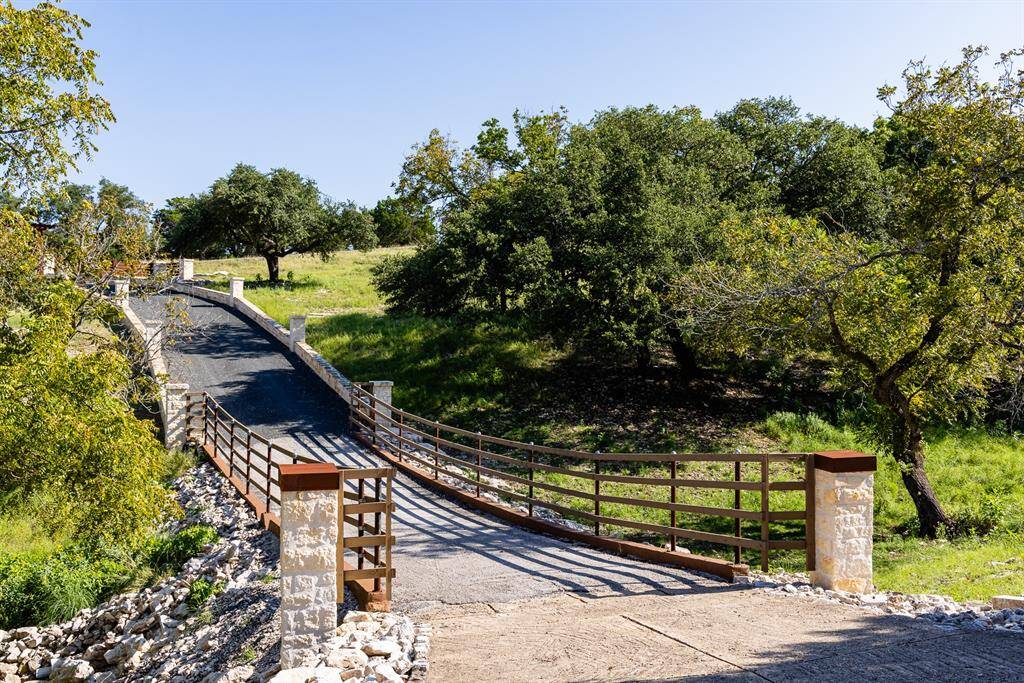 Extra wide 250' driveway, flanked by 24' custom stone retaining walls & flagstone-capped columns.