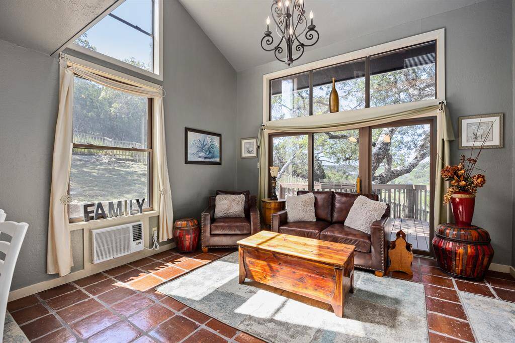 Living room in the guest house with vaulted ceiling, handcrafted chandelier, private deck, kitchen & laundry area,