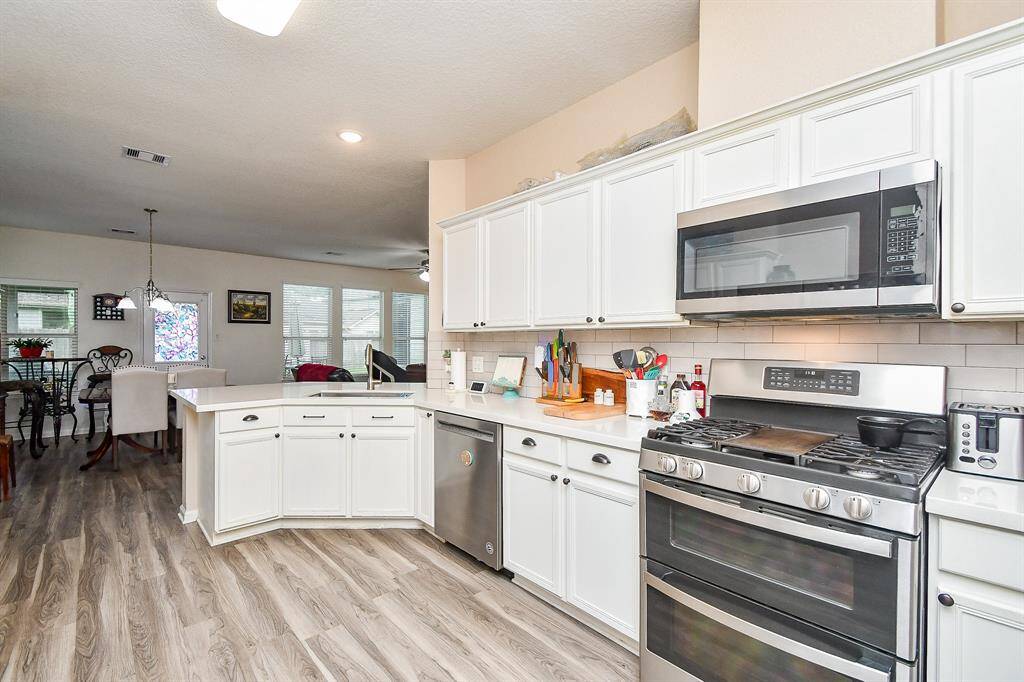 The open layout flows into a bright dining area with large windows, perfect for entertaining