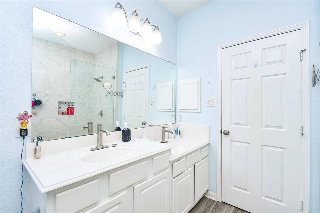 This bathroom features a modern design with a large mirror and dual sinks