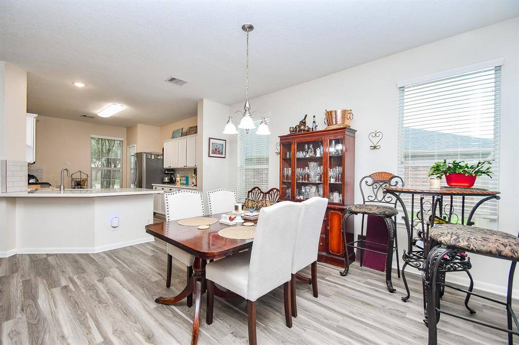 The photo showcases the bright dining area. Large windows provide ample natural light, enhancing the inviting atmosphere.