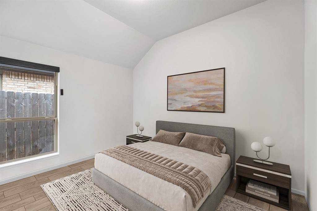 This stunning bedroom boasts custom paint, a large window with stylish roller shades, and elegant wood-look tile flooring, creating a warm and inviting space!