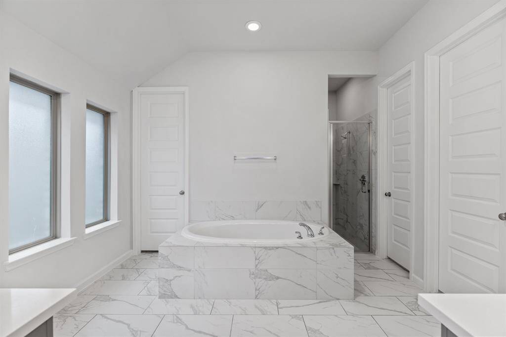 End your days in luxury with this oversized soaking bathtub, a spacious walk-in shower, and recessed lighting, creating the perfect retreat for relaxation!