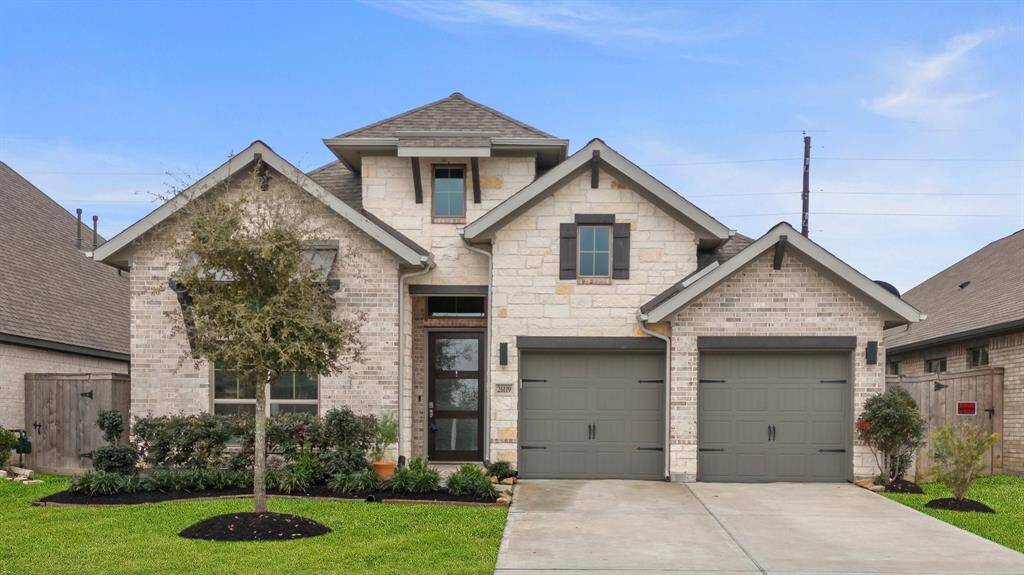 This stunning Perry Home boasts a beautiful brick and stone elevation, a spacious 2-car epoxy garage, and meticulously maintained landscaping with a lush green lawn, offering fantastic curb appeal!