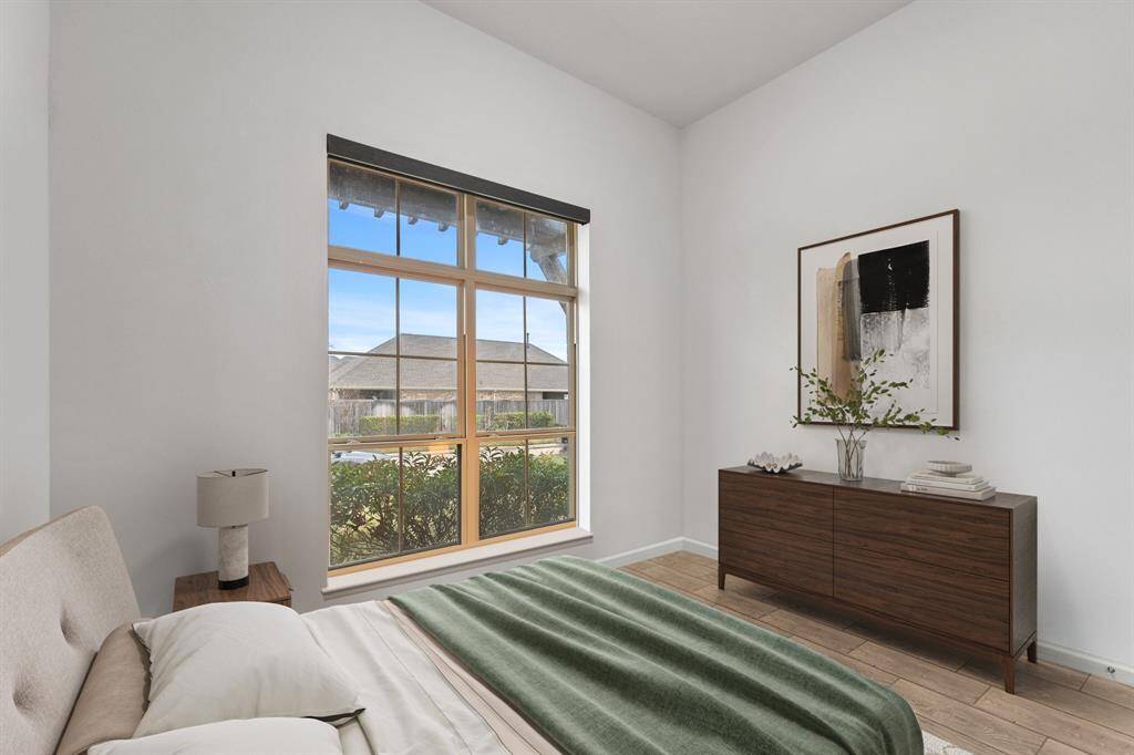 This spacious bedroom boasts high ceilings, a large window with sleek roller shades, and elegant tile flooring, creating a bright and stylish retreat! *Virtually Staged*