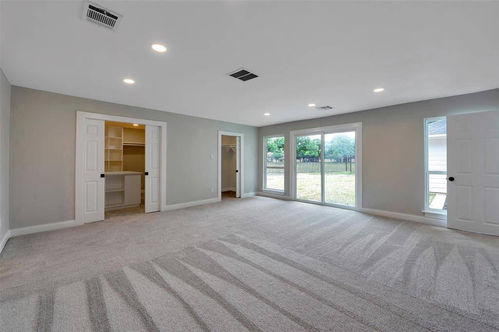 The primary bedroom with recent carpet, recessed lighting and sliding glass door to the backyard. So many updates! All interior doors thoughout the home were also replaced 2024.