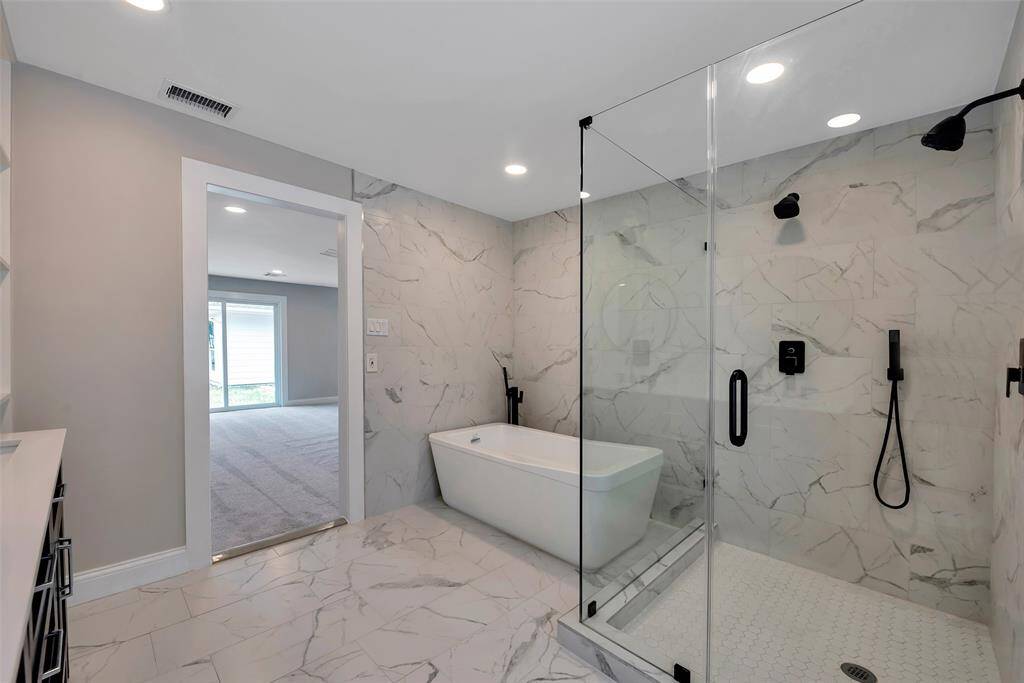 There is also a freestanding soaking tub, plus a spacious and 2-person seamless glass shower with rainhead and adjust arm sprayer. All done in 2024.