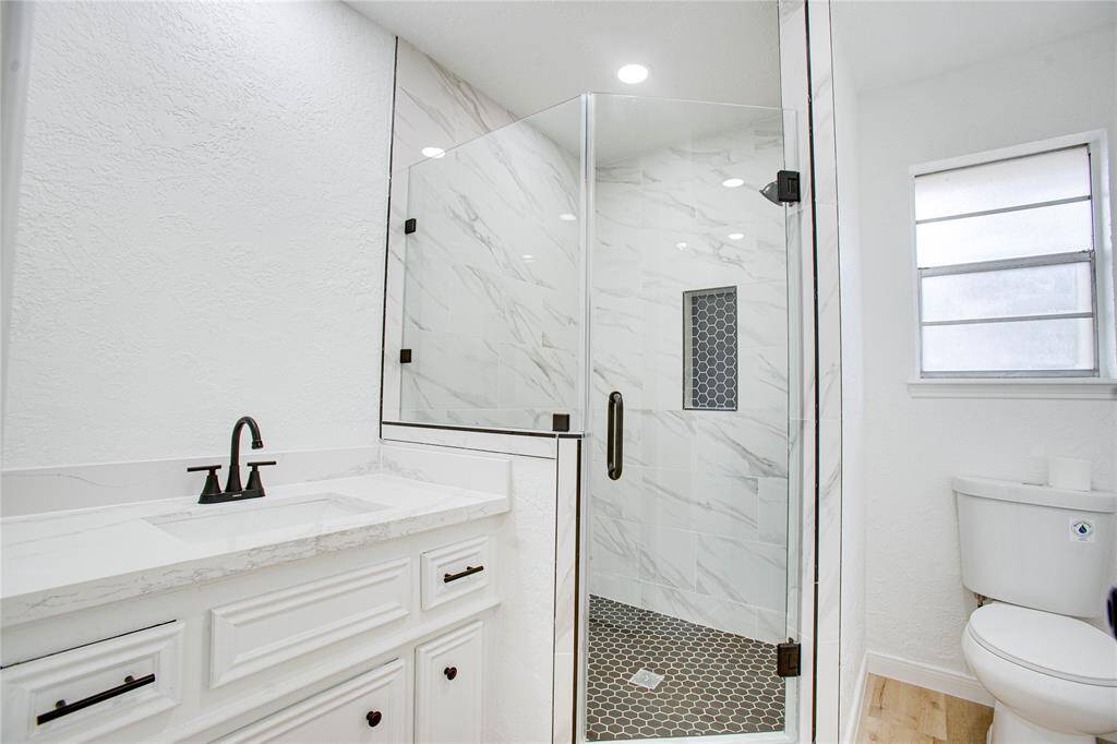 Primary restroom offers a towering shower that was fully renovated from head to toe along with new Quartz countertops!
