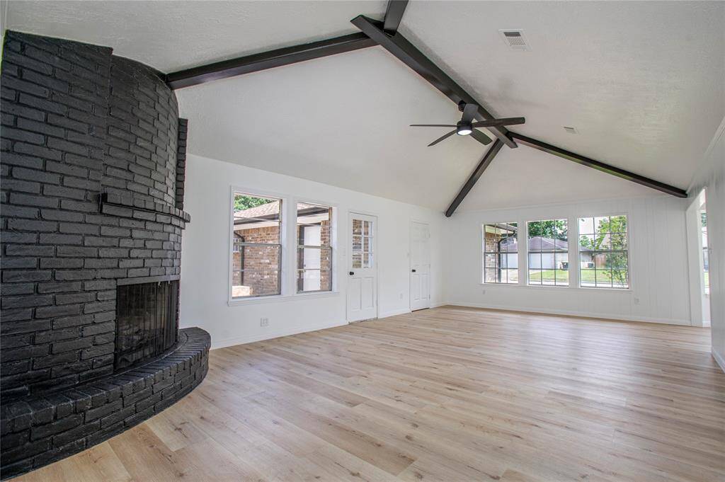 Living room that offers high ceilings, cozy fireplace and an enormous amount of natural light!