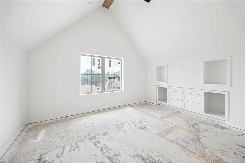 Third floor bedroom has custom built-ins and vaulted ceilings.