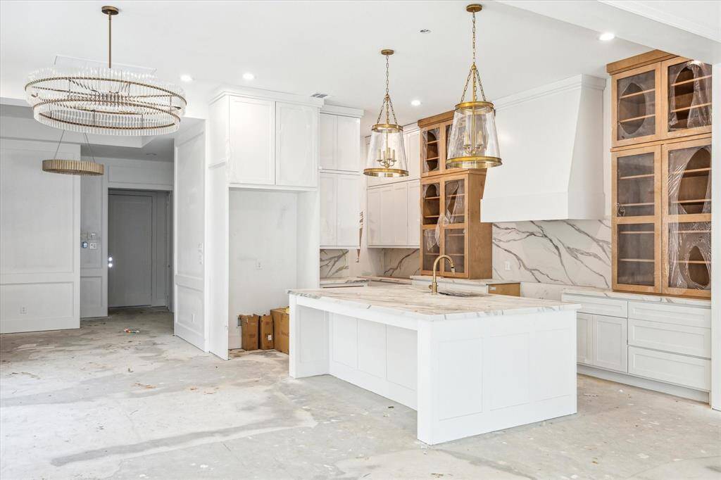Spacious island allows for seating and prep area. Sophisticated pendent lights with panelled design along the island add a unique design and create a polished and cohesive space.