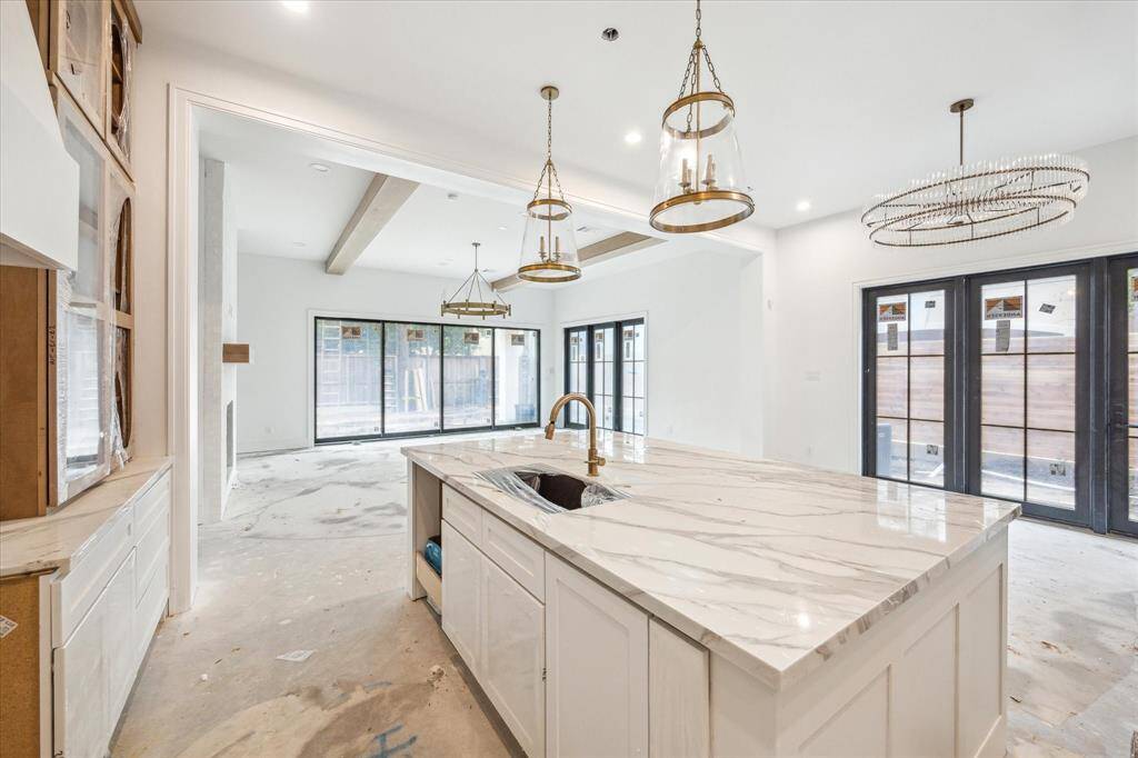 Kitchen features spacious island with Quartz countertops and breakfast bar overlooking dining space and living room.