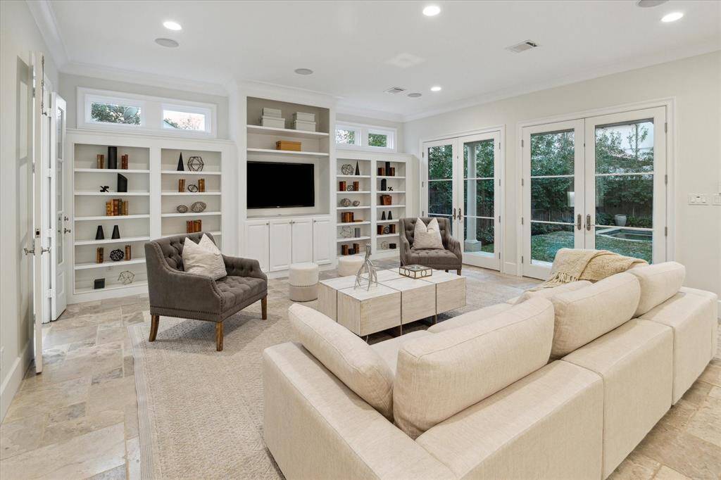 The expansive family room with two sets of French doors offer ample natural light and views of the lush backyard.