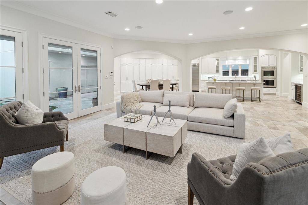 The airy open-concept family room, kitchen, and breakfast area with surplus natural light from the row of French doors.