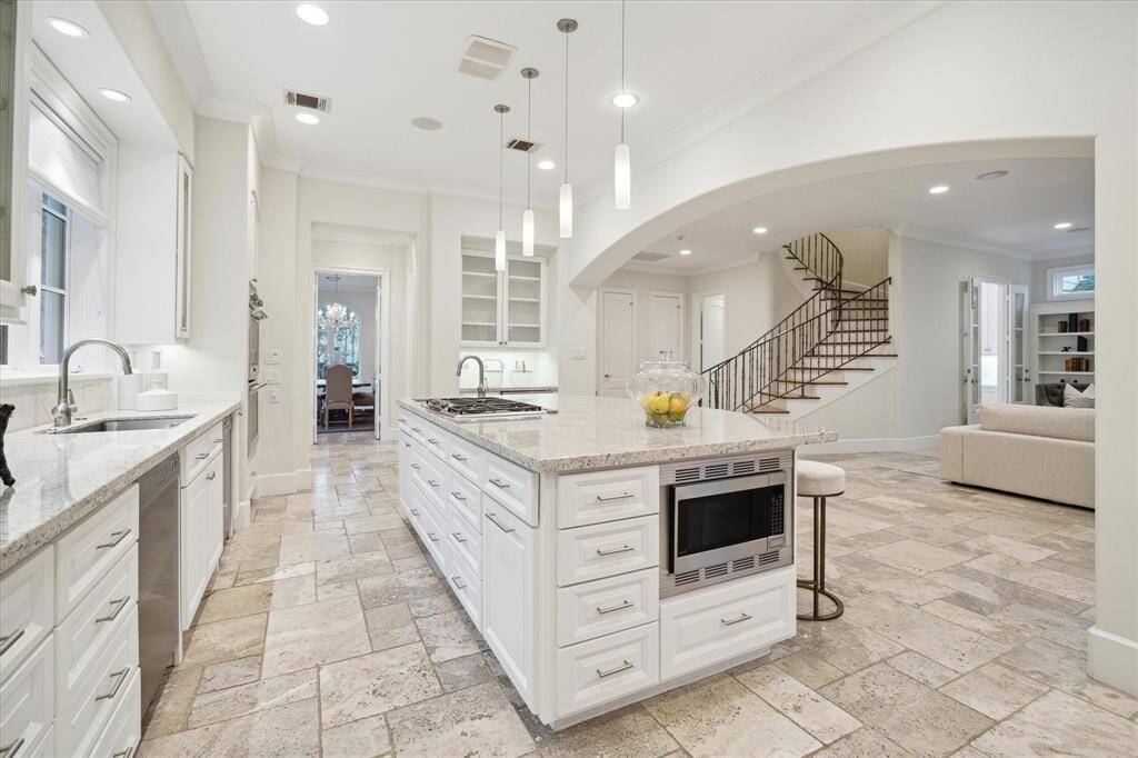 The kitchen area has seamless flow to the adjacent living area and dining room. The elegant staircase adds a touch of sophistication.