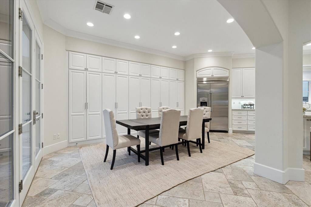 This spacious breakfast area features a sleek, modern design with a wall lined with ample built-in cabinetry creating a great space for casual dining.