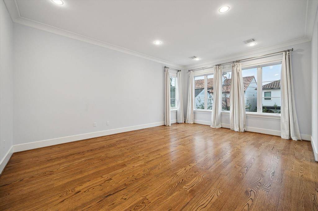 Luxurious primary suite with expansive windows and abundant natural light from the great windows.
