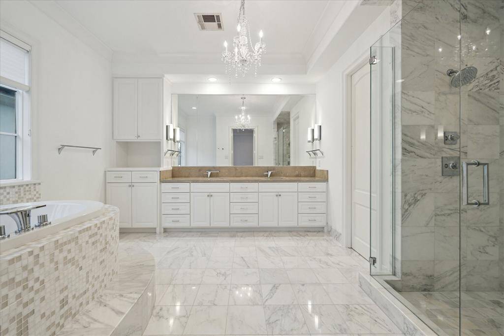 Experience ultimate elegance in the primary bathroom, featuring a luxurious raised bathtub and a spacious, stylish walk-in shower.