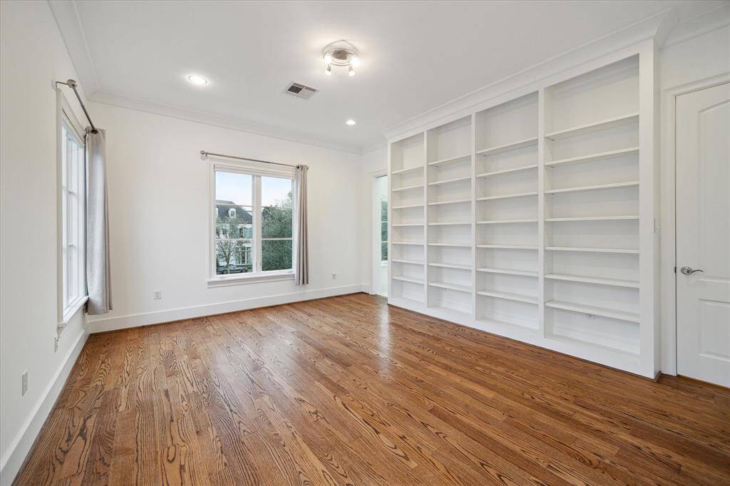 Spacious secondary bedroom featuring extensive built-in shelving for all your storage needs.