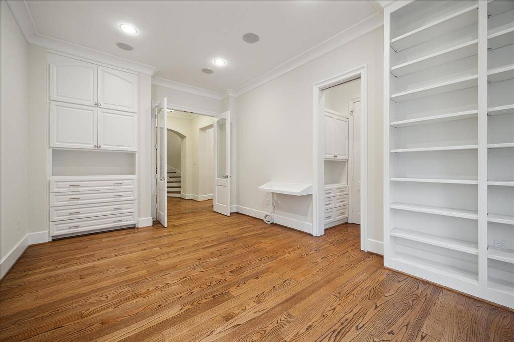 Elegant second-floor study with built-in shelves and ample storage.