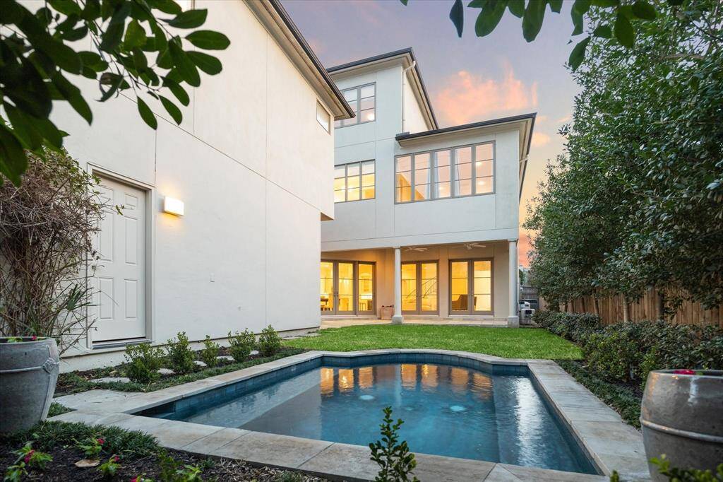 The home showcases a modern backyard with a luxurious dipping pool surrounded by manicured landscaping. Perfect for relaxation or entertaining.