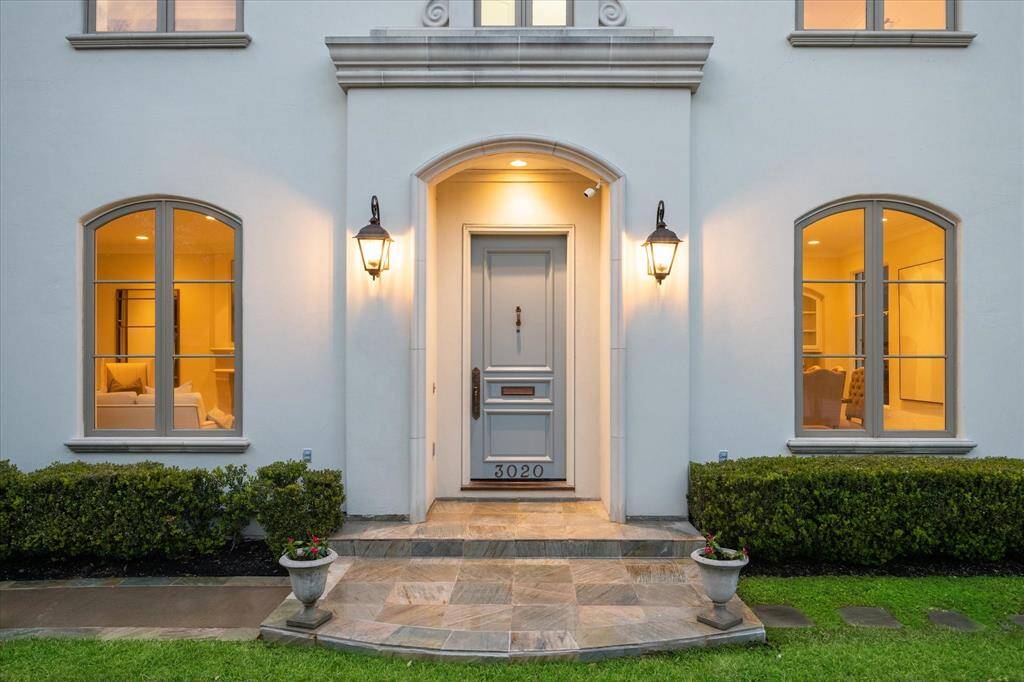 The front facade features a stone walkway, and tidy landscaping, creating a welcoming and sophisticated curb appeal.