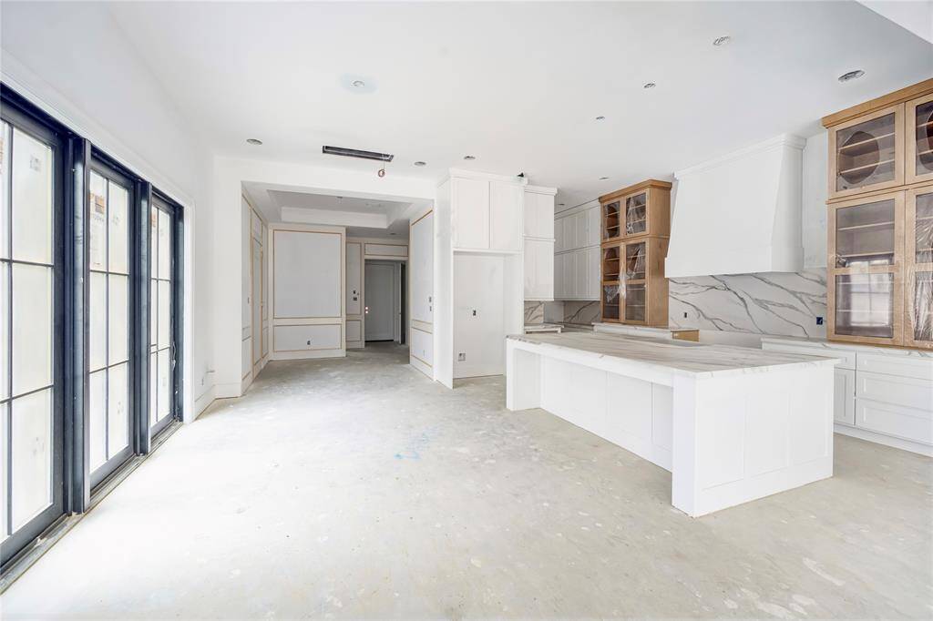 Spacious island allows for seating and prep area. Sophisticated pendent lights with fluted design along the island and hood add a unique design and create a polished and cohesive space. *Photo is for reference and not of the exact home.
