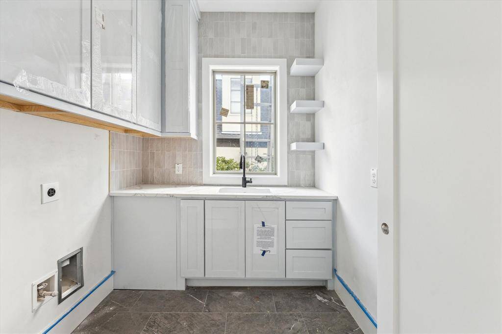 Second floor is completed by utility room with built-in storage, vertical subway tile backsplash, 25" undermount sink, and floating shelves.