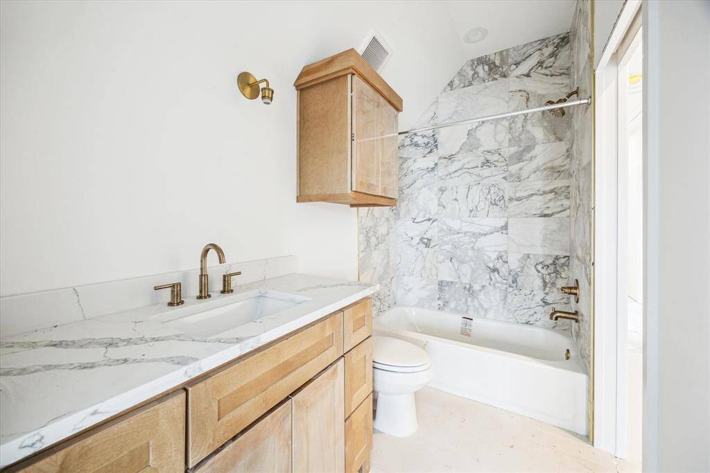 Third floor full bathroom with tile wall along the shower, Quartz countertops, and additional storage. *Photo is for reference and not of the exact home.