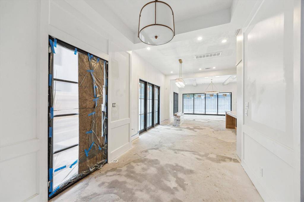 Entryway with chandelier and coffered ceiling, panelling on walls, and checkered tile floors to be added.
