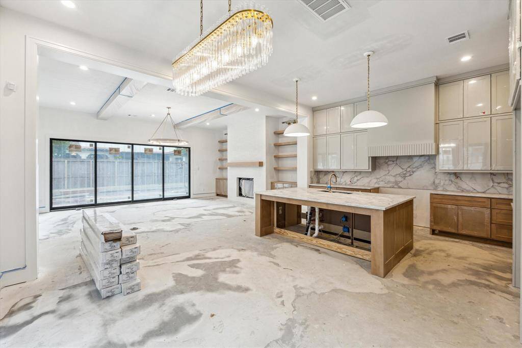 Kitchen features spacious island with Quartz countertops and breakfast bar overlooking dining space and living room.