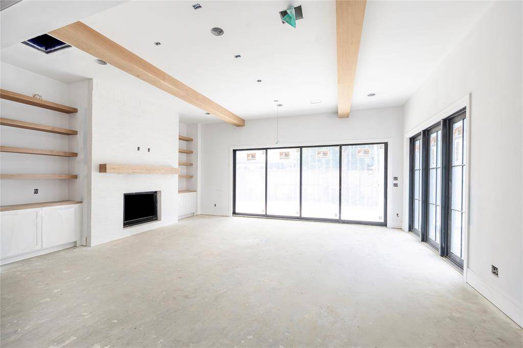 Off the living space is a wall of sliding glass doors that open to exterior pavilion with 65-inch ceiling fan, treated wood ceiling, granite countertop, and optional summer kitchen buildout. *Photo is for reference and not of the exact home.