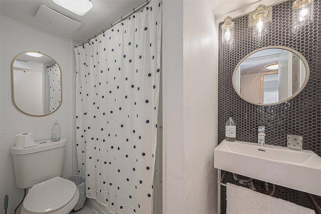 Absolute stunning remodeled bathroom with richly appointed sink, fixtures and hardware. Bathroom was taken down to the studs and completely remodeled, converting tub to a walk-in shower. Dramatic lighting and mirror and floor to ceiling tile.