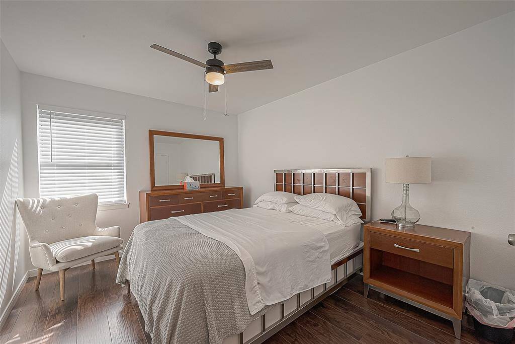 Good sized primary bedroom with recent flooring a contemporary ceiling fan, and good looking window treatments.