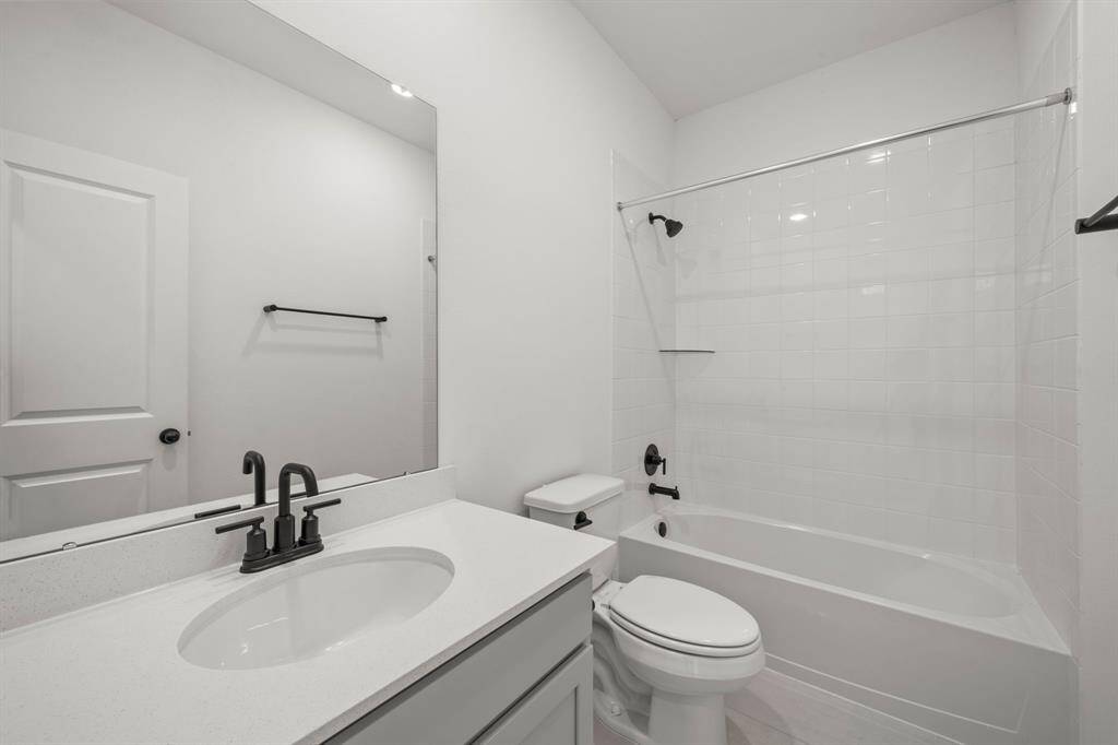The secondary bath features tile flooring, white cabinetry and light countertops and a shower/tub combo. Perfect for accommodating any visiting family and friends.