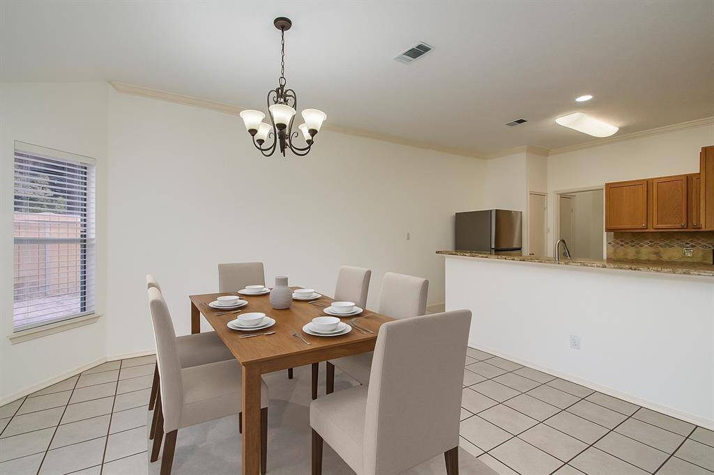 View of the ample sized dining room and kitchen. Perfect for entertaining and family meals! (virtually staged)