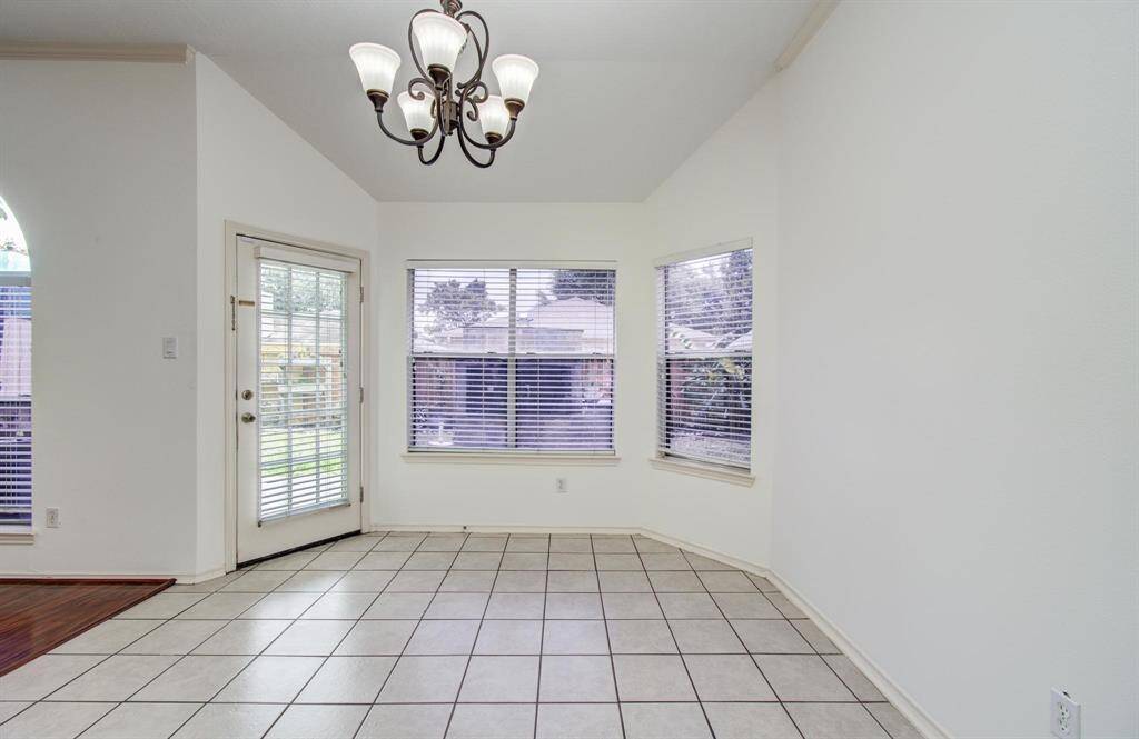 Bay of windows, glass patio door and a classic chandelier bring natural light and backyard views to every meal.