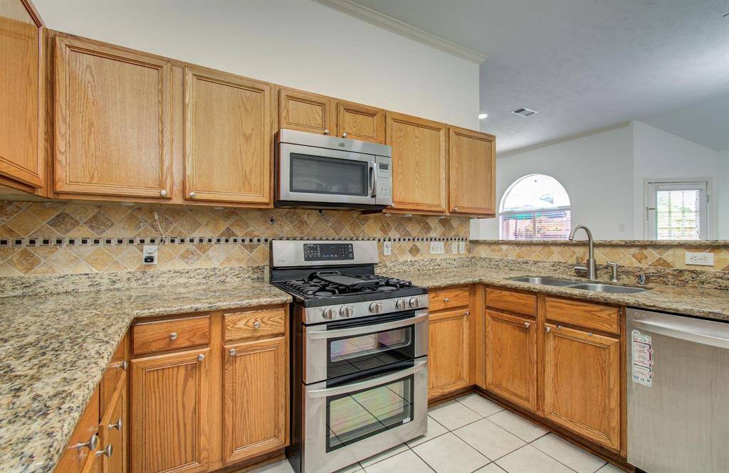 Storage galore - Raised -panel oak cabinetry wraps the kitchen, keeping everything organized and within reach.