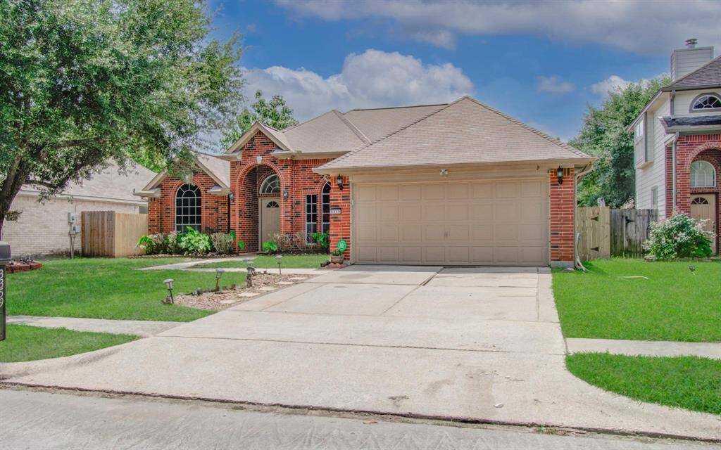 Handsome, brick facade, mature shade tree and a lawn frame this single-story charmer with an oversized two-car garage.