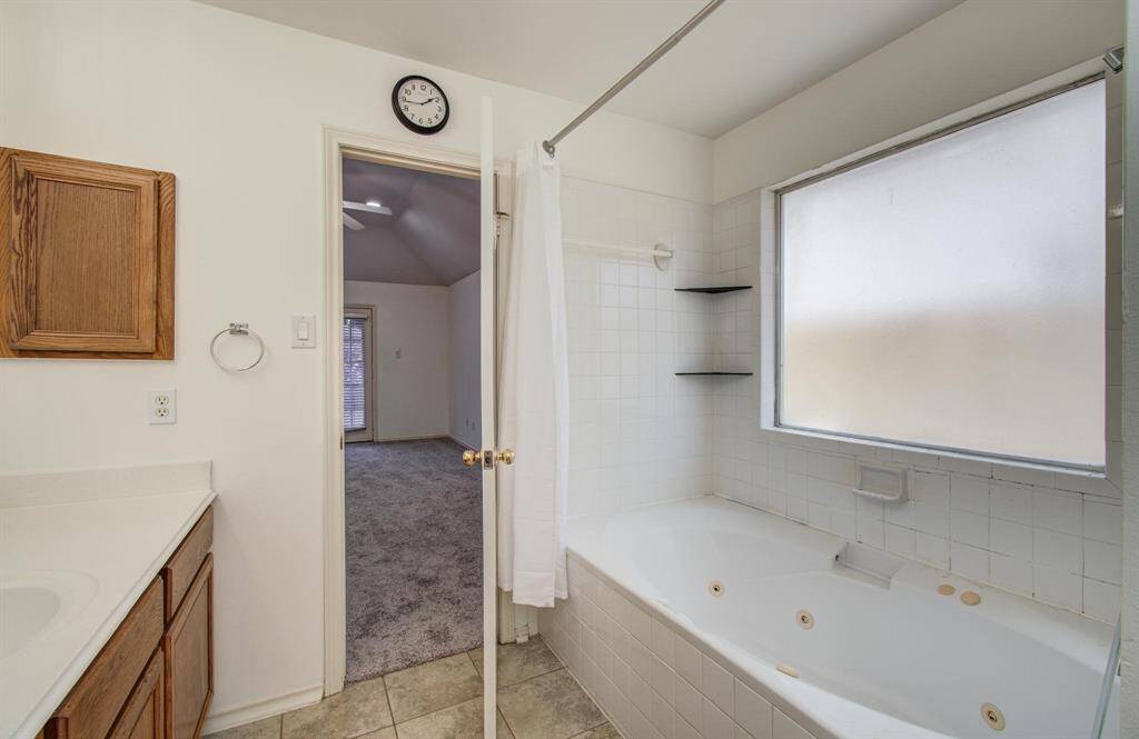 Spa-style primary bath – Long vanity with updated lighting, soaking tub/shower combo and neutral finishes await your personal touch.