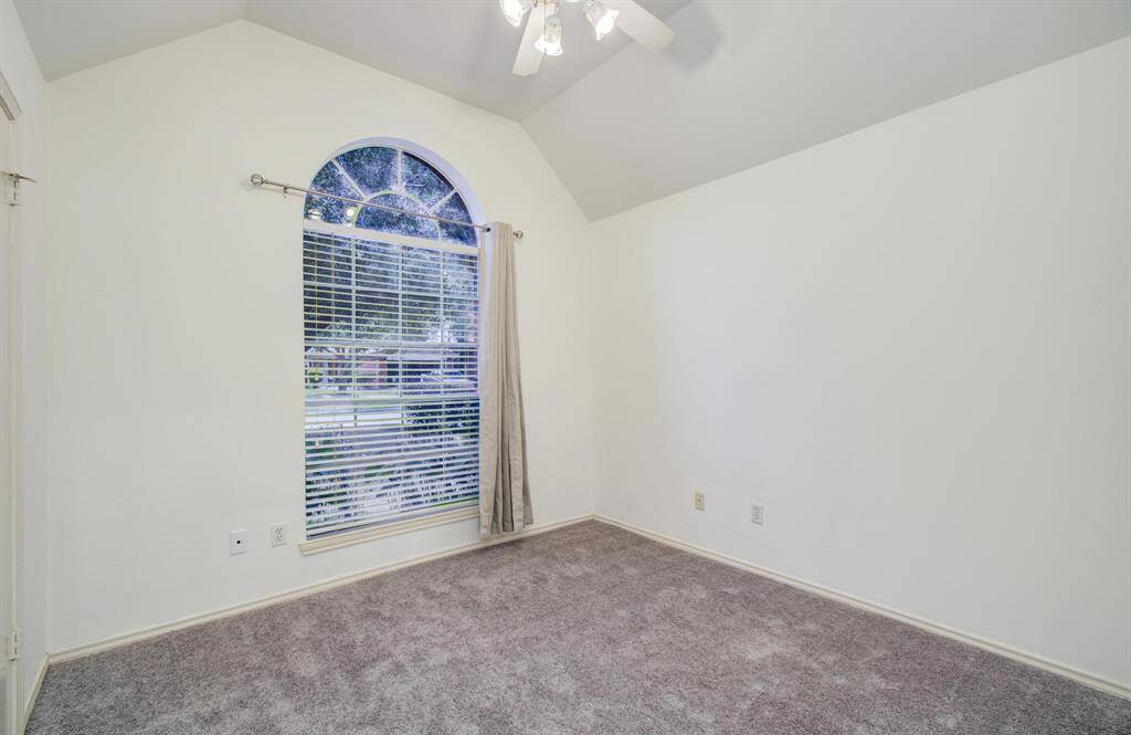 Secondary bedroom – Vaulted ceiling, arched window and fresh new carpet offer a bright, restful retreat.